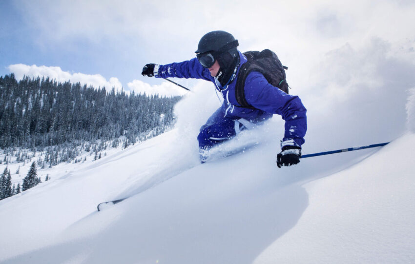 skier on snow covered mountain against sky